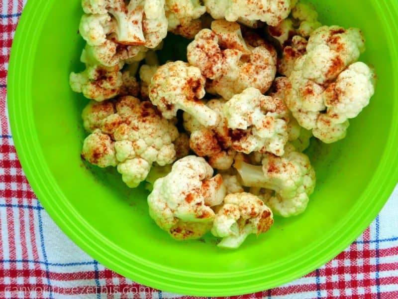 Mixing cauliflower with paprika and olive oil